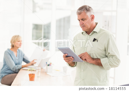 Attentive businessman working on the tablet Attentive businessman working on the tablet 18114555