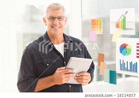 Smiling businessman holding a digital tablet 18114857