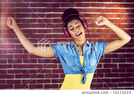 A smiling woman dancing with headphones A smiling woman dancing with headphones 18115019