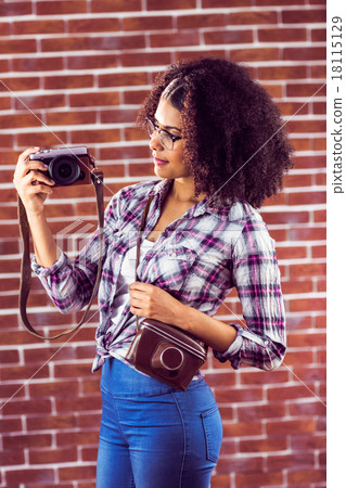 Attractive hipster holding camera and looking at it 18115129