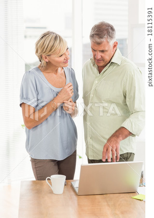 Attentive business team discussing over a laptop Attentive business team discussing over a laptop 18115391