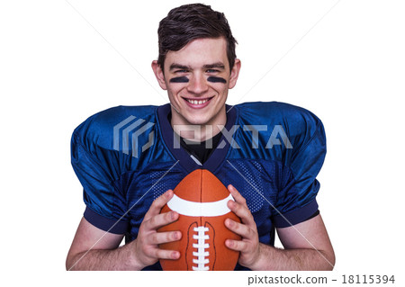 Smiling american football player holding a ball Smiling american football player holding a ball 18115394