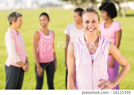Smiling blonde wearing pink for breast cancer in front of friend 18115395