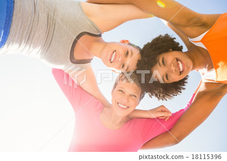 Sporty women with arms around smiling down to camera Sporty women with arms around smiling down to camera 18115396