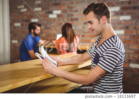 Young man reading a newspaper Young man reading a newspaper 18115697
