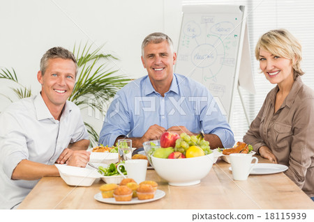Smiling business colleagues having lunch together Smiling business colleagues having lunch together 18115939