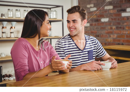Cute couple drinking a coffee together Cute couple drinking a coffee together 18115972