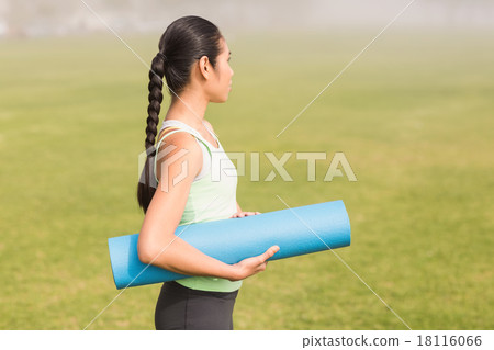 Sporty woman holding exercise mat 18116066