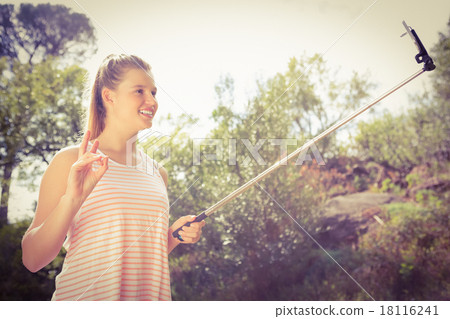 Pretty blonde showing peace sign and taking selfies Pretty blonde showing peace sign and taking selfies 18116241