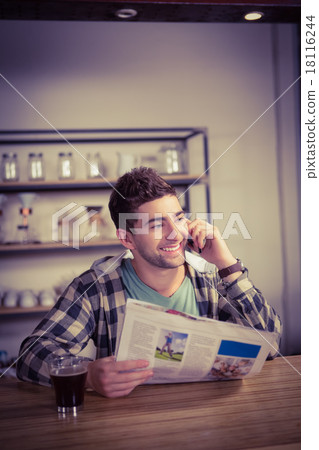 Smiling hipster phoning and holding newspaper 18116244