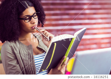 Casual businesswoman looking in her diary 18116251