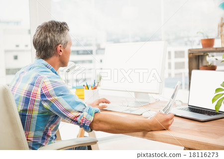 Casual designer editing photos with computer 18116273