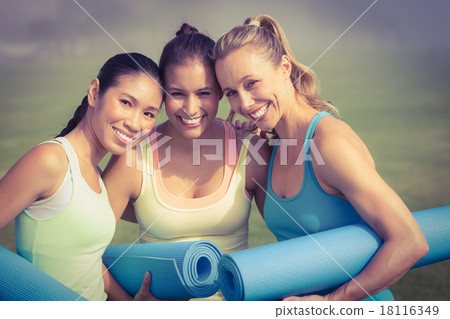 Laughing sporty women with exercise mats 18116349