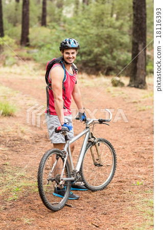 Happy handsome biker holding bike and looking at camera 18116393