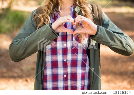 Blonde hiker framing heart with hands 18116394