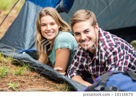Portrait of a young happy couple lying in a tent Portrait of a young happy couple lying in a tent 18116679