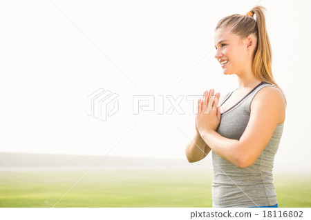 Smiling sporty blonde meditating 18116802