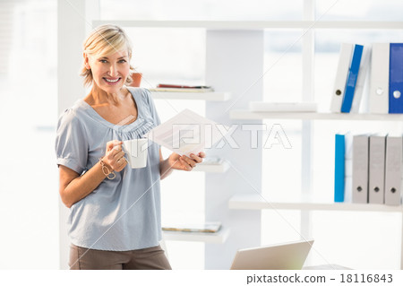 Smiling businesswoman holding a document Smiling businesswoman holding a document 18116843