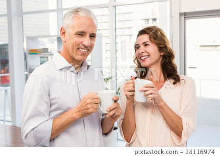 Smiling casual business colleagues having coffee together Smiling casual business colleagues having coffee together 18116974