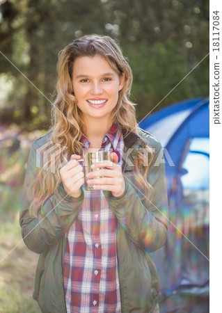 Smiling blonde camper standing in front of tent 18117084