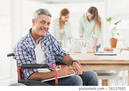 Casual businessman in wheelchair with notepad 18117085