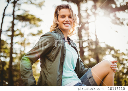 Young happy jogger sitting on rock and looking at camera Young happy jogger sitting on rock and looking at camera 18117210