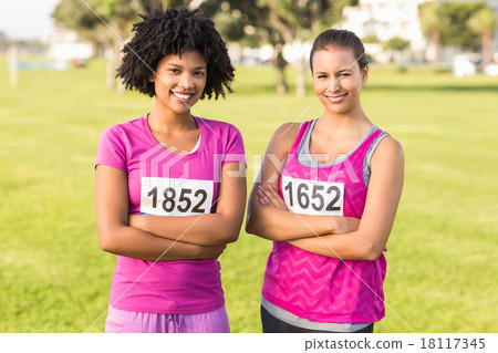 Two smiling runners supporting breast cancer marathon Two smiling runners supporting breast cancer marathon 18117345
