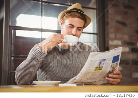 Handsome hipster drinking coffee and reading newspaper 18117430