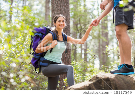 Happy hikers climbing on rock and smiling at camera Happy hikers climbing on rock and smiling at camera 18117549