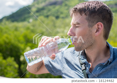 man drinking water from a bottle, sunny day. 18124482