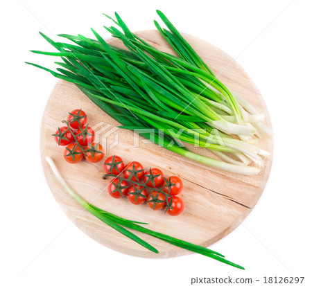 Green onion and cherry on wooden platter. Green onion and cherry on wooden platter. 18126297