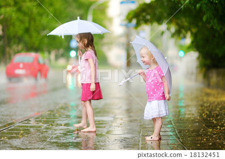 Two cute little sisters on a rainy summer day Two cute little sisters on a rainy summer day 18132451