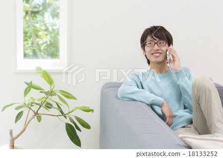 A young man who puts a smartphone on his ear A young man who puts a smartphone on his ear 18133252