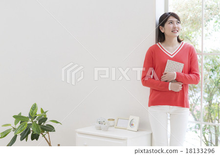 A young woman leaning against the window 18133296