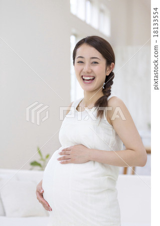 把她的手放的孕婦在她的胃上 18133554