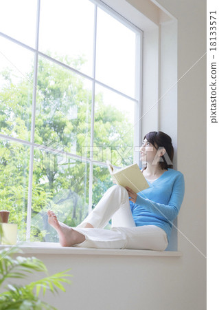 Young lady sitting on the window side 18133571