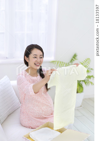 看著嬰兒衣服的婦女 看著嬰兒衣服的婦女 18133597