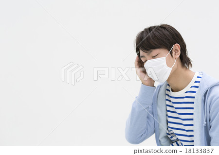 一個年輕人掩蓋並把手放在他的頭上 18133837