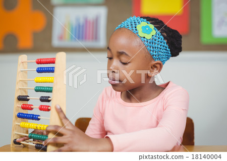 Focused pupil calculating with abacus in a classroom 18140004