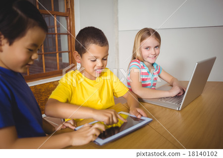 Cute pupils in class using laptop and tablet Cute pupils in class using laptop and tablet 18140102