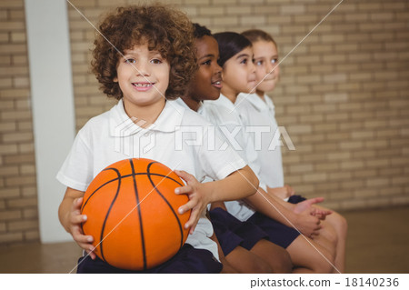 Student holding basketball with fellow players Student holding basketball with fellow players 18140236