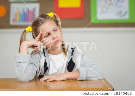 Thoughtful pupil sitting at her desk in a classroom Thoughtful pupil sitting at her desk in a classroom 18140498