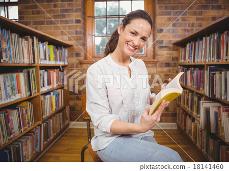 Smiling teacher reading a book 18141460