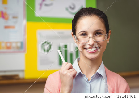 Teacher smiling at camera in classroom Teacher smiling at camera in classroom 18141461