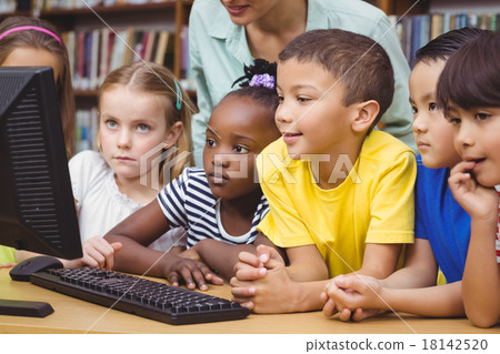 Pupils and teacher in the library using computer 18142520