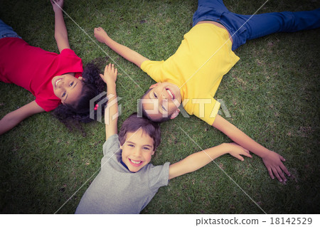 Cute pupils lying on grass smiling 18142529