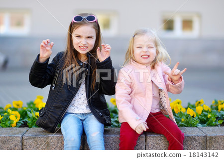 Portrait of two cute little sisters outdoors Portrait of two cute little sisters outdoors 18143142