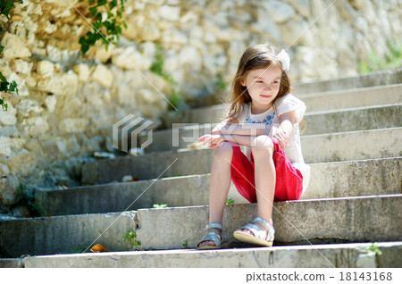 Adorable little girl sitting on stairs Adorable little girl sitting on stairs 18143168
