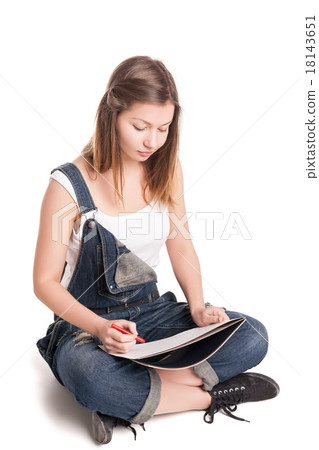 Young woman happily sitting cross-legged on the 18143651