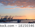 Cranes in a harbor at sunset 18150346